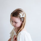 Young girl with butterfly hair clips on a plain background