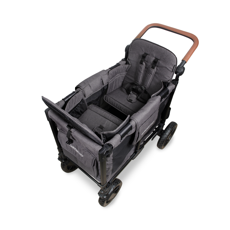 A high-angle studio shot of a stroller wagon attachment set against a solid white background. The stroller features a dark gray fabric body with a brown wooden handlebar and black wheels.