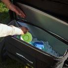 Person reaching into a Wonderbag cooler with ice packs