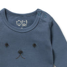 Close-up of a blue baby outfit with bear ears and nose on a white background