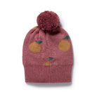 Knitted hat with pom-pom and fruit pattern on a white background