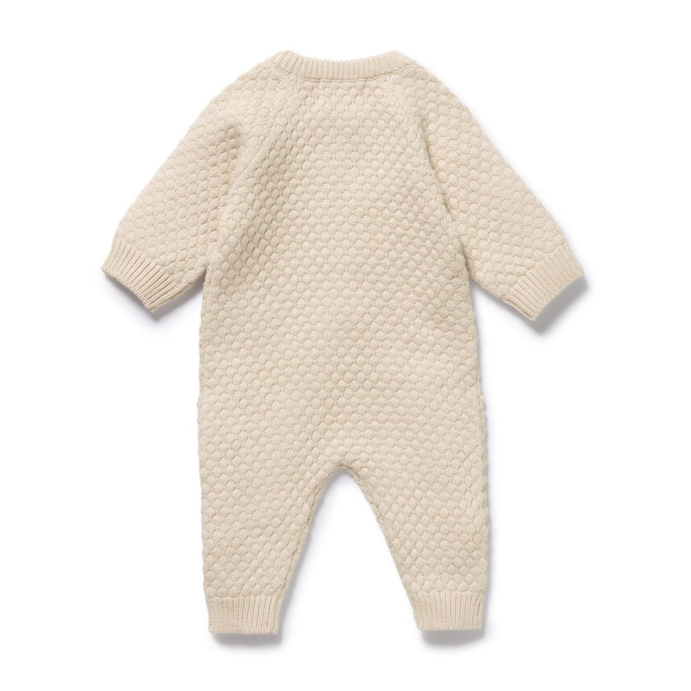 Beige knitted baby romper on a white background