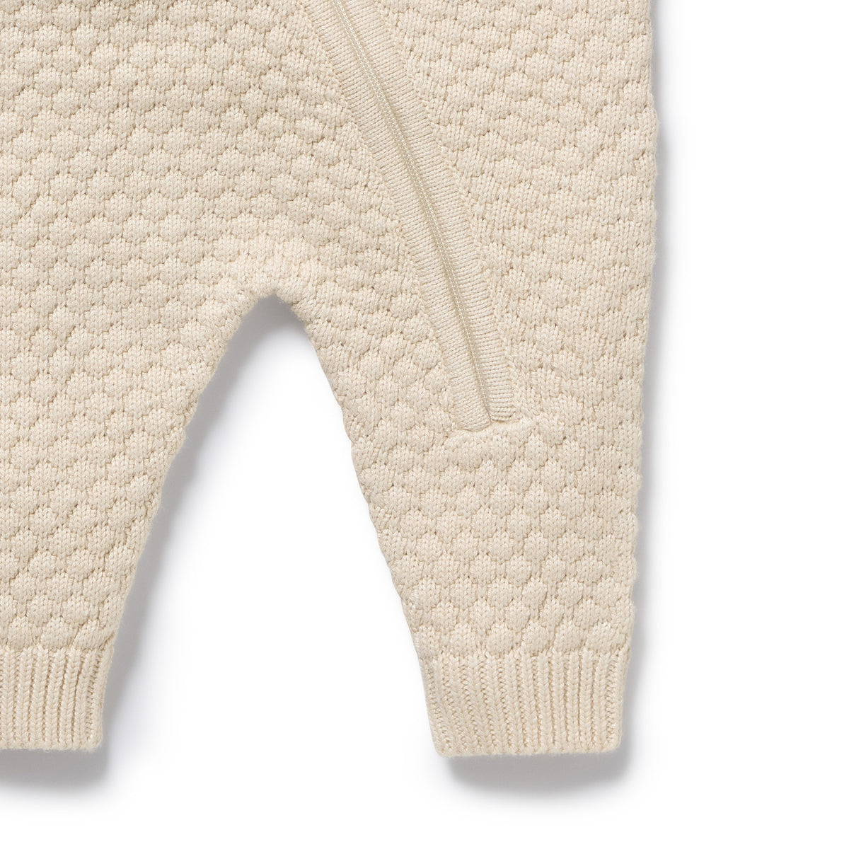 Close-up of beige textured baby romper on a white background