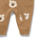 Brown knitted baby pants with bear face patterns on a white background