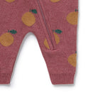 Pink baby romper with orange and green pattern on a white background