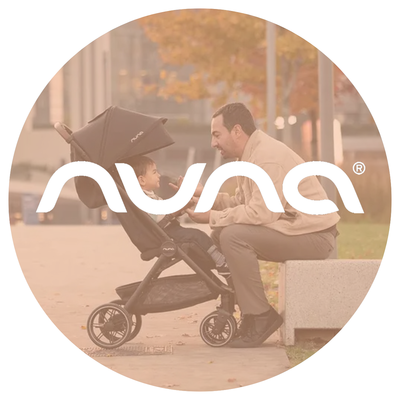 Dad with a 1 year old in a black stroller sitting in front of a tree with fall leaves