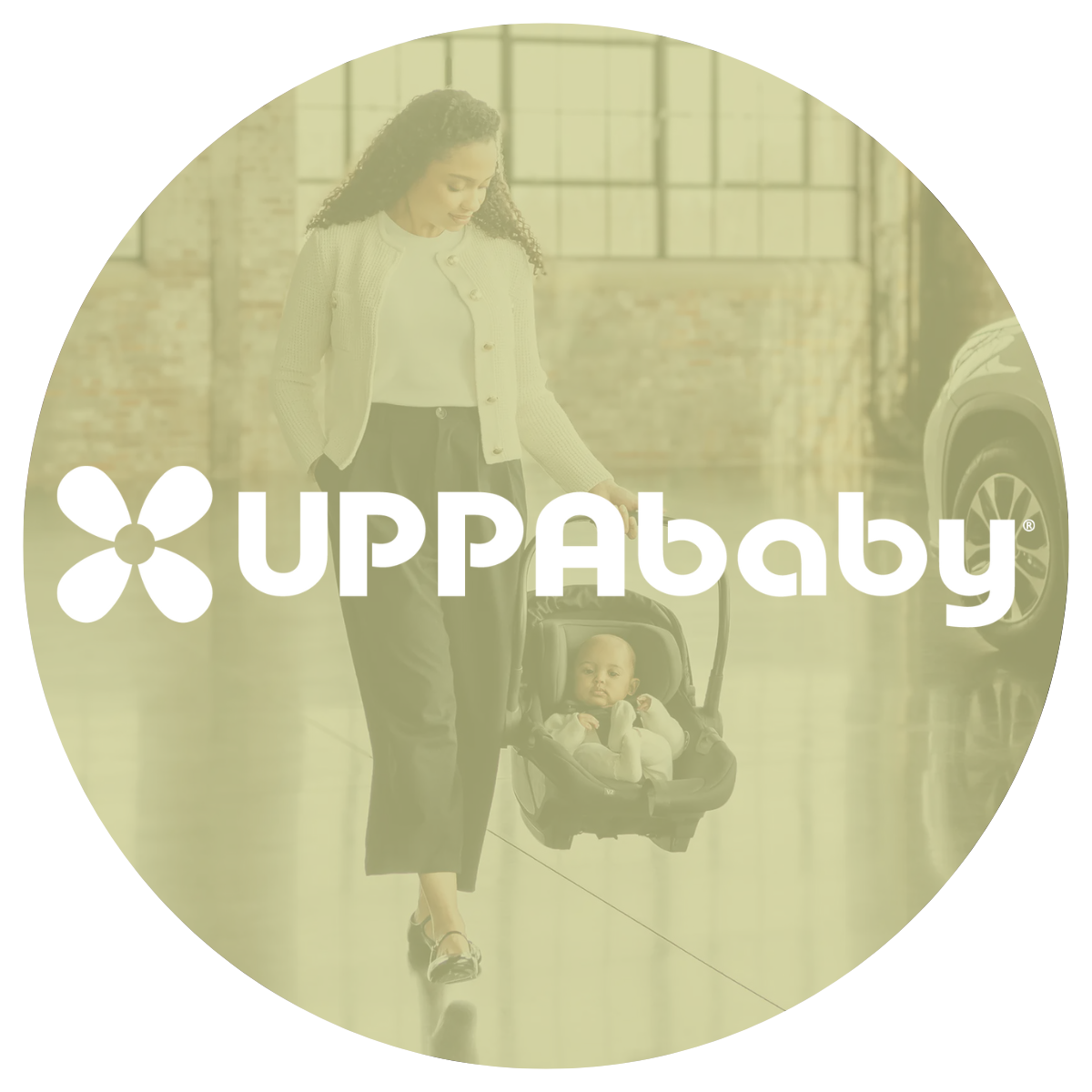 Mom walking in a warehouse space holding a baby in an infant car seat 