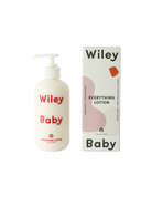 A bottle of Wiley Baby Everything Lotion next to its product box, both featuring a clean white design with red and pink graphic accents on a solid white background.