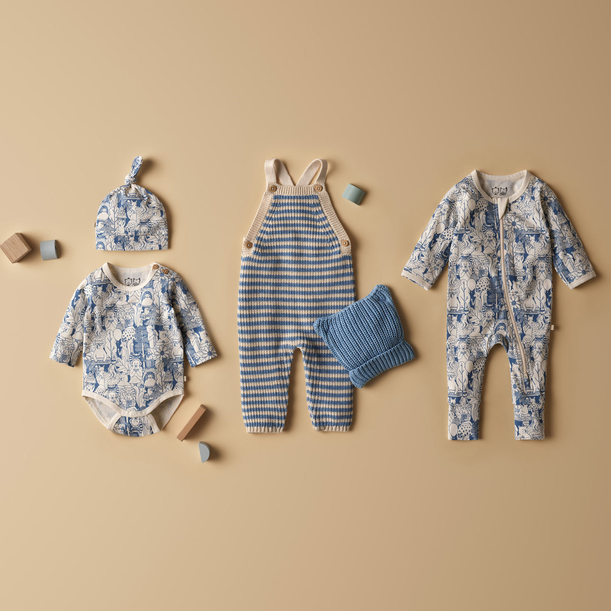Collection of baby clothing and accessories on a beige background