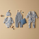 Collection of baby clothing and accessories on a beige background