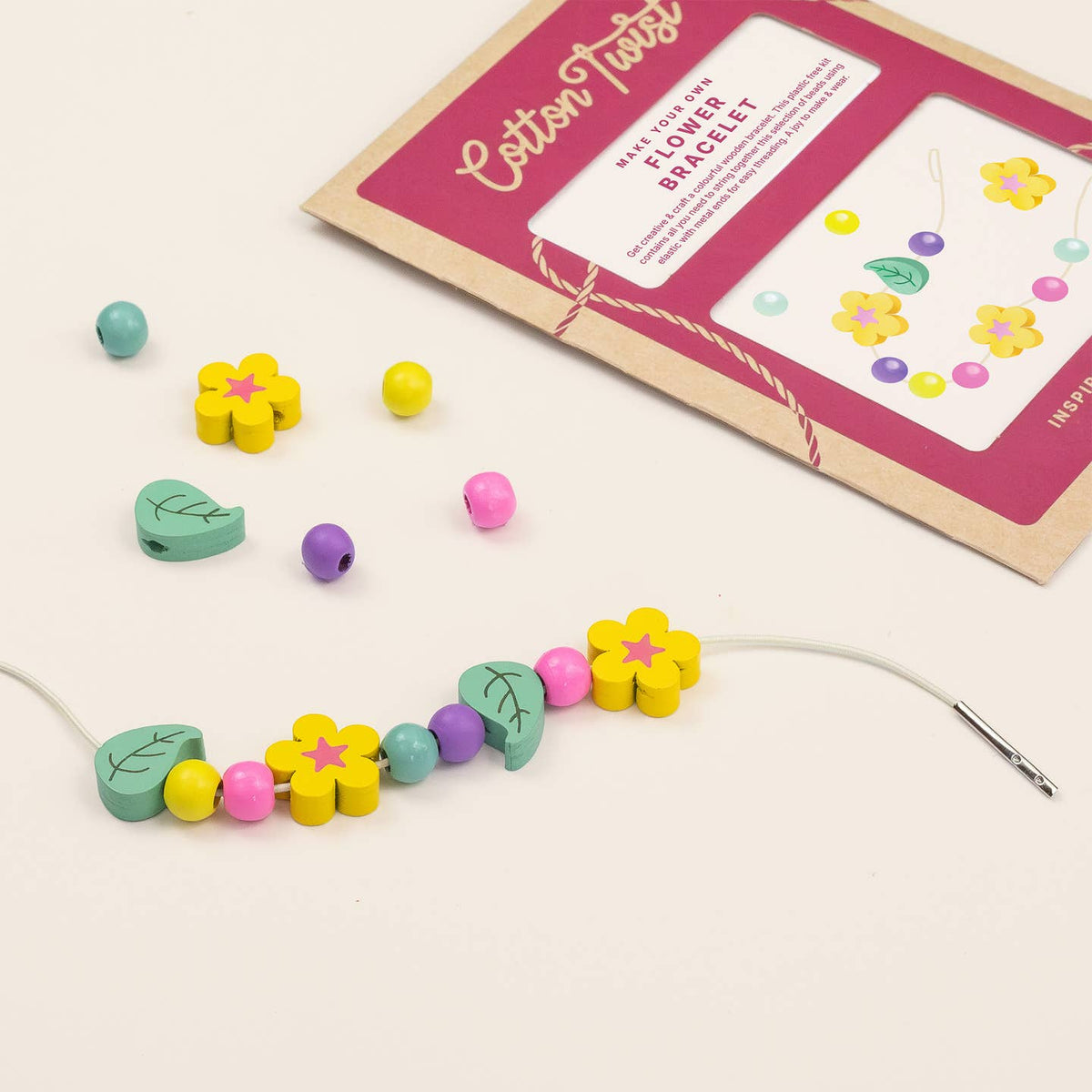 Colorful beaded flower bracelet with a craft kit on a light background
