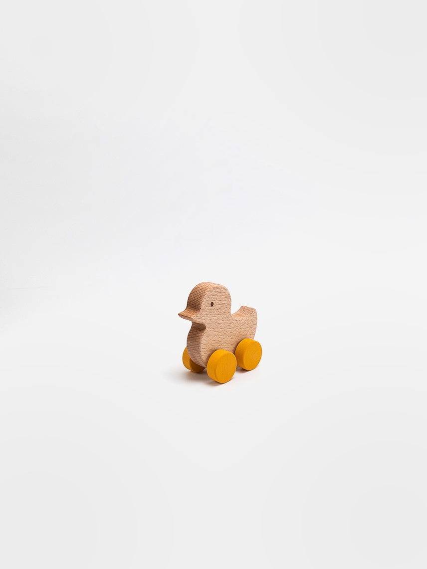 Wooden duck toy with wheels on a white background