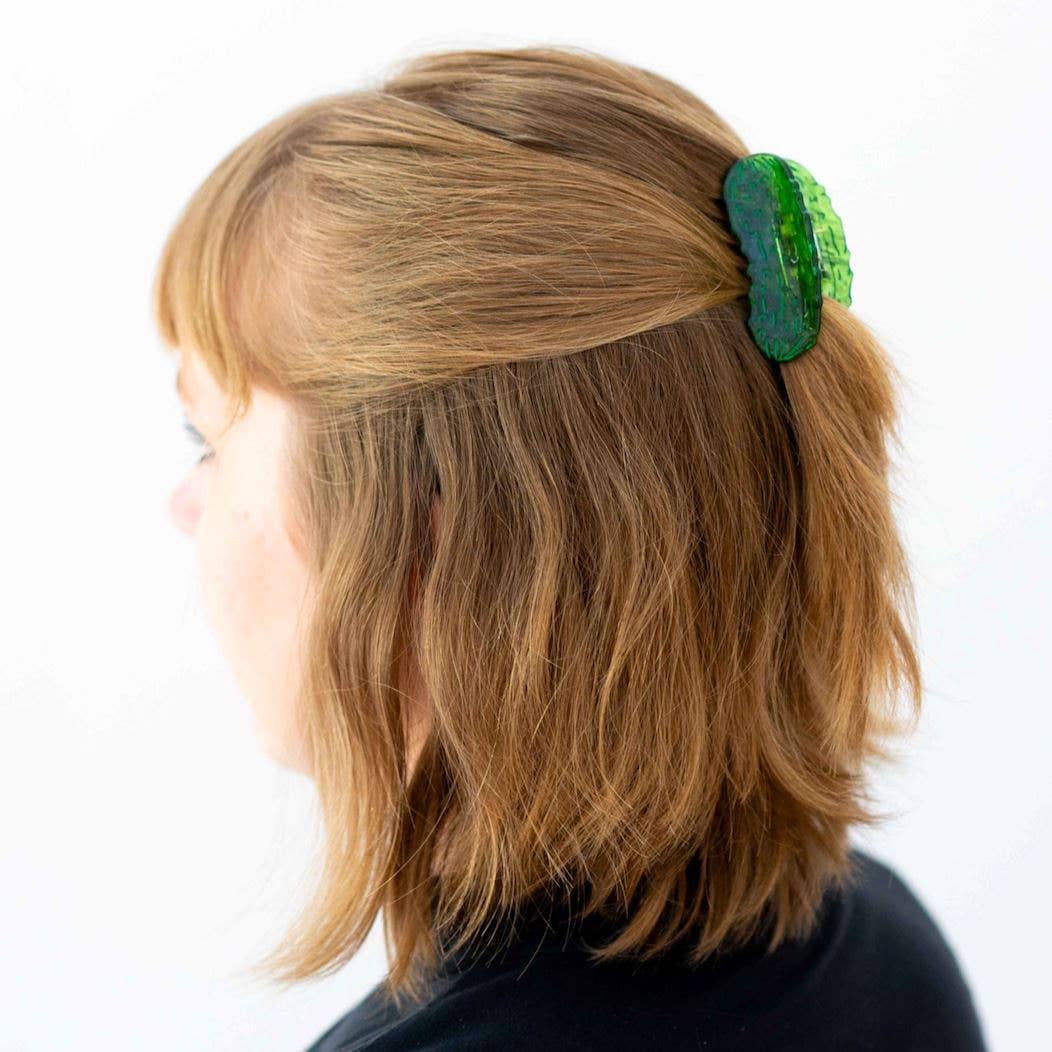Person with a green hair clip in their hair on a white background