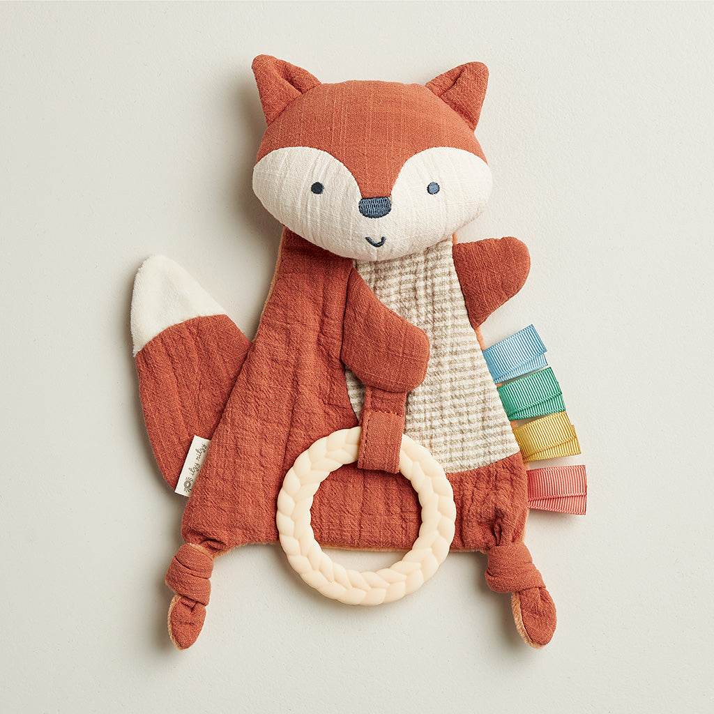 Plush fox toy with a ring and colorful fabric on a light background
