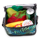  insulated lunch bag with colorful leaf pattern containing a sandwich, apple, banana, and drinks.