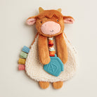 Plush cow toy with colorful elements on a light background