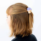Person with a hair clip shaped like an ice cream cone on a white background