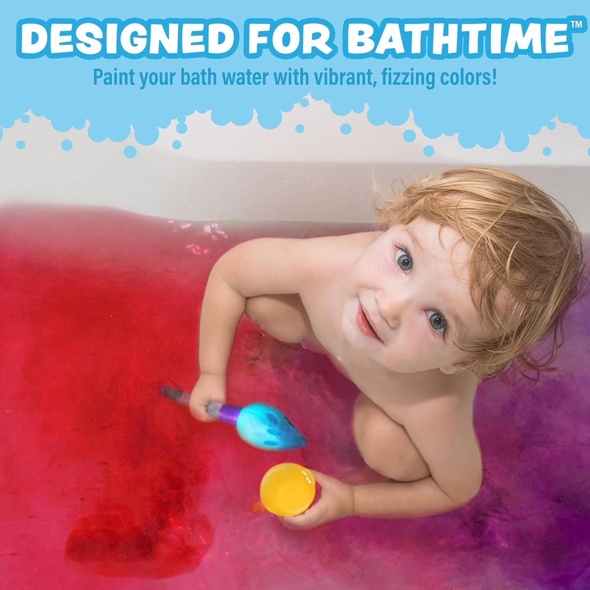 Child in a bathtub with colorful water, holding a toy with blue and yellow colors.
