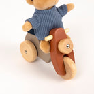 Wooden toy with a bear-like figure wearing a blue sweater on a white background