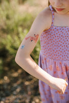 Child wearing a purple dress with floral patterns outdoors