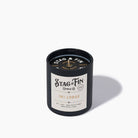 Stag & Fin candle with black lid and white label on a light gray background