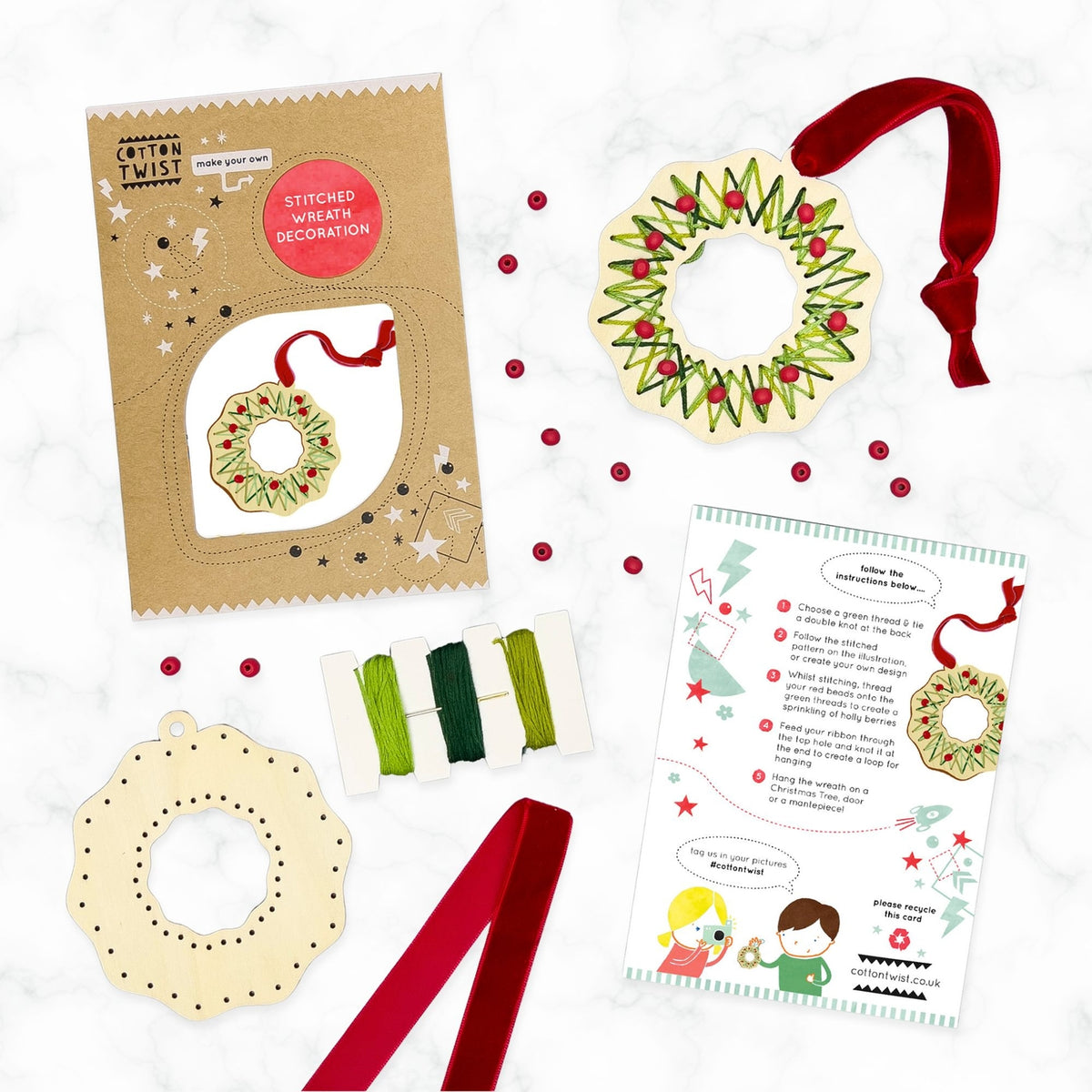 Craft kit with wreath decoration, ribbons, and instructions on a white background
