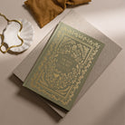 Decorative book with ornate cover on a beige surface