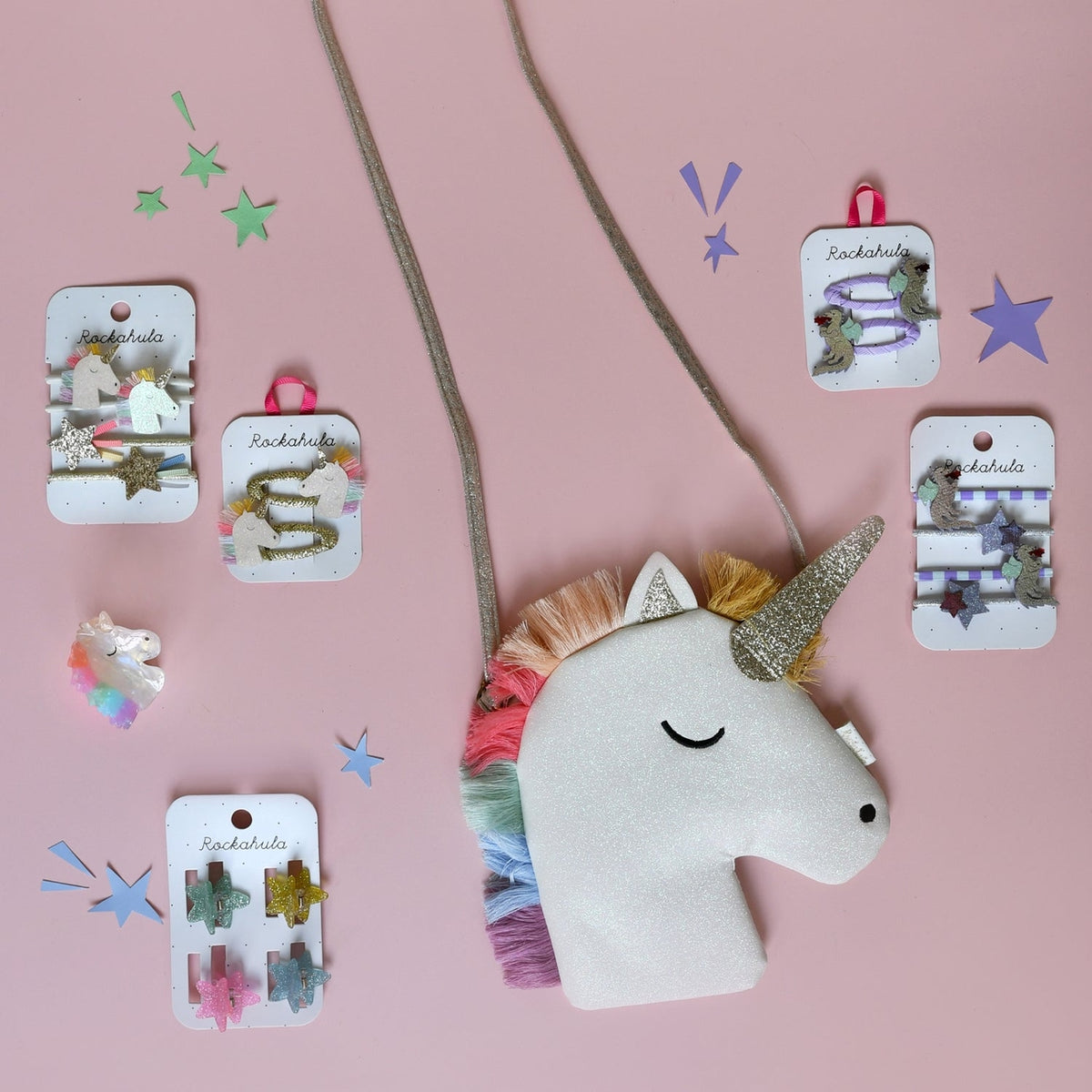 Unicorn headband with decorative hair clips on a pink background