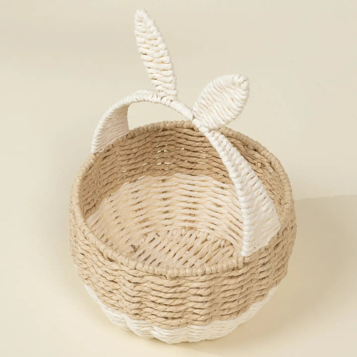 Woven basket with bunny ears on a beige background