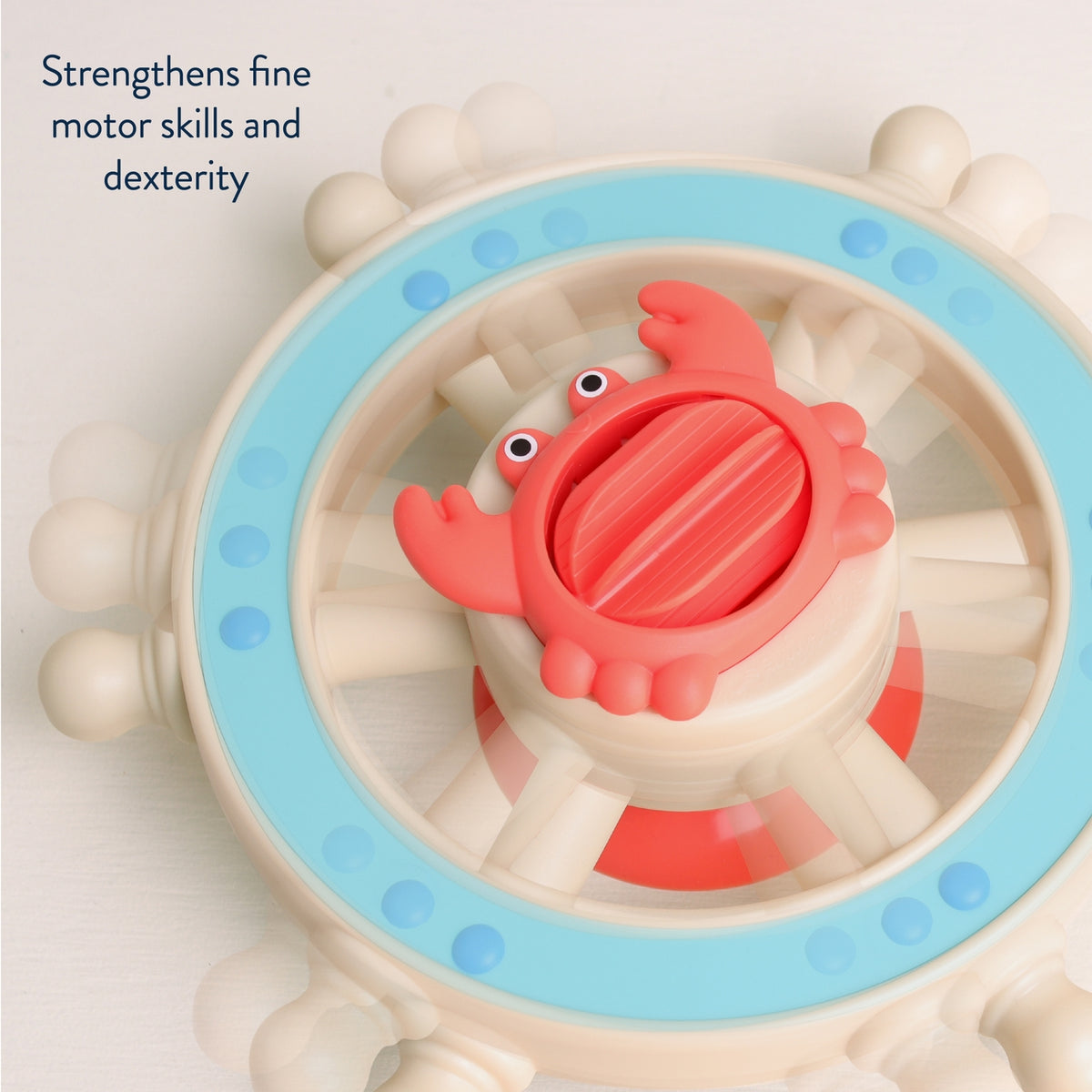Toy wheel with a red crab-shaped center on a light background