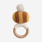 Crocheted teething ring with wooden ring on a white background