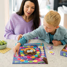 Woman and child playing a board game together on a table.
