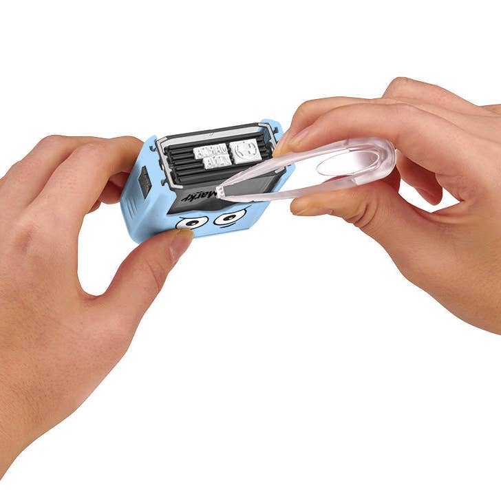 Person using a small blue device with a face design on a white background