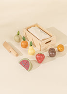 Set of wooden fruit toys with a box on a beige background