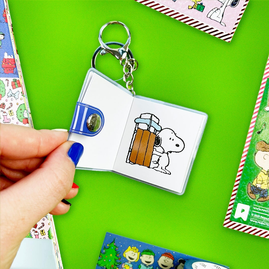 Keychain with a small open book featuring a cartoon character on a green background