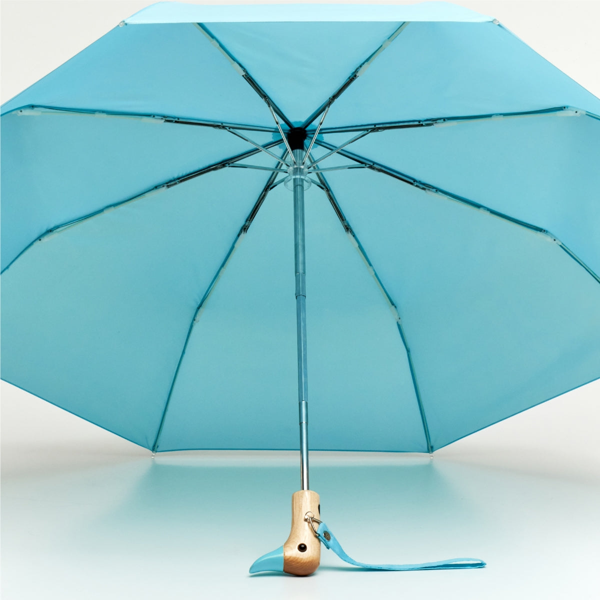 Blue umbrella with wooden handle on a light blue background