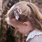 Child with decorative hair clips in a natural setting