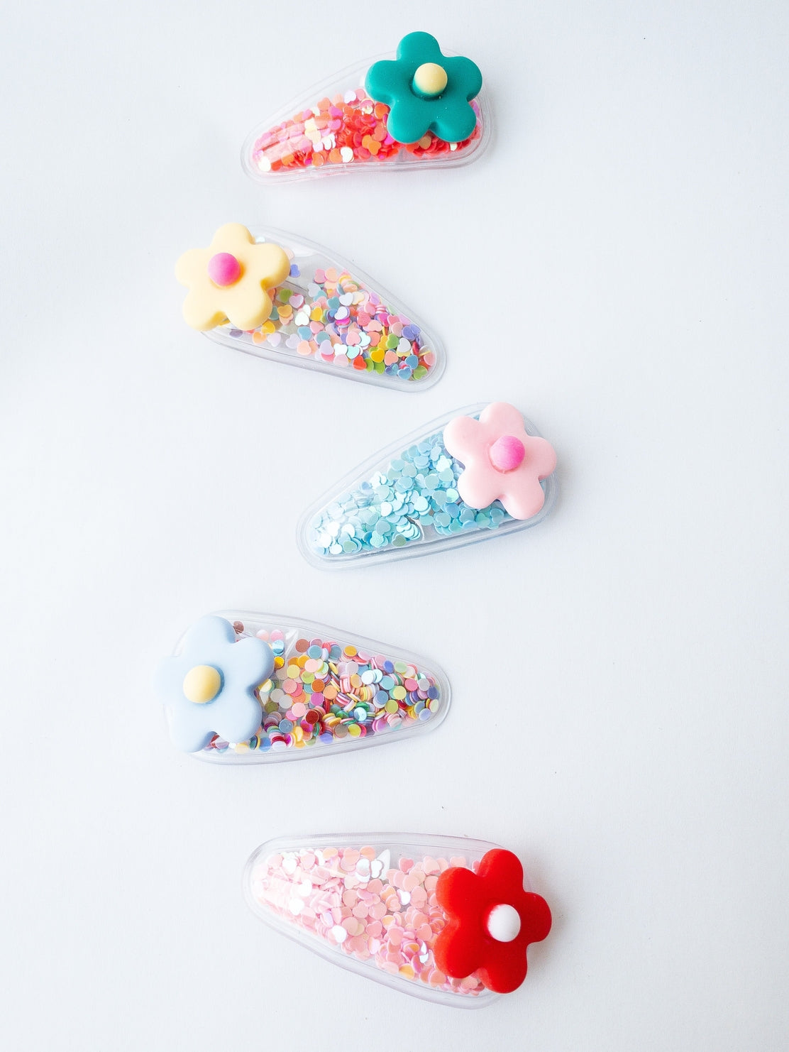 Set of colorful hair clips with flowers and sequins on a white background