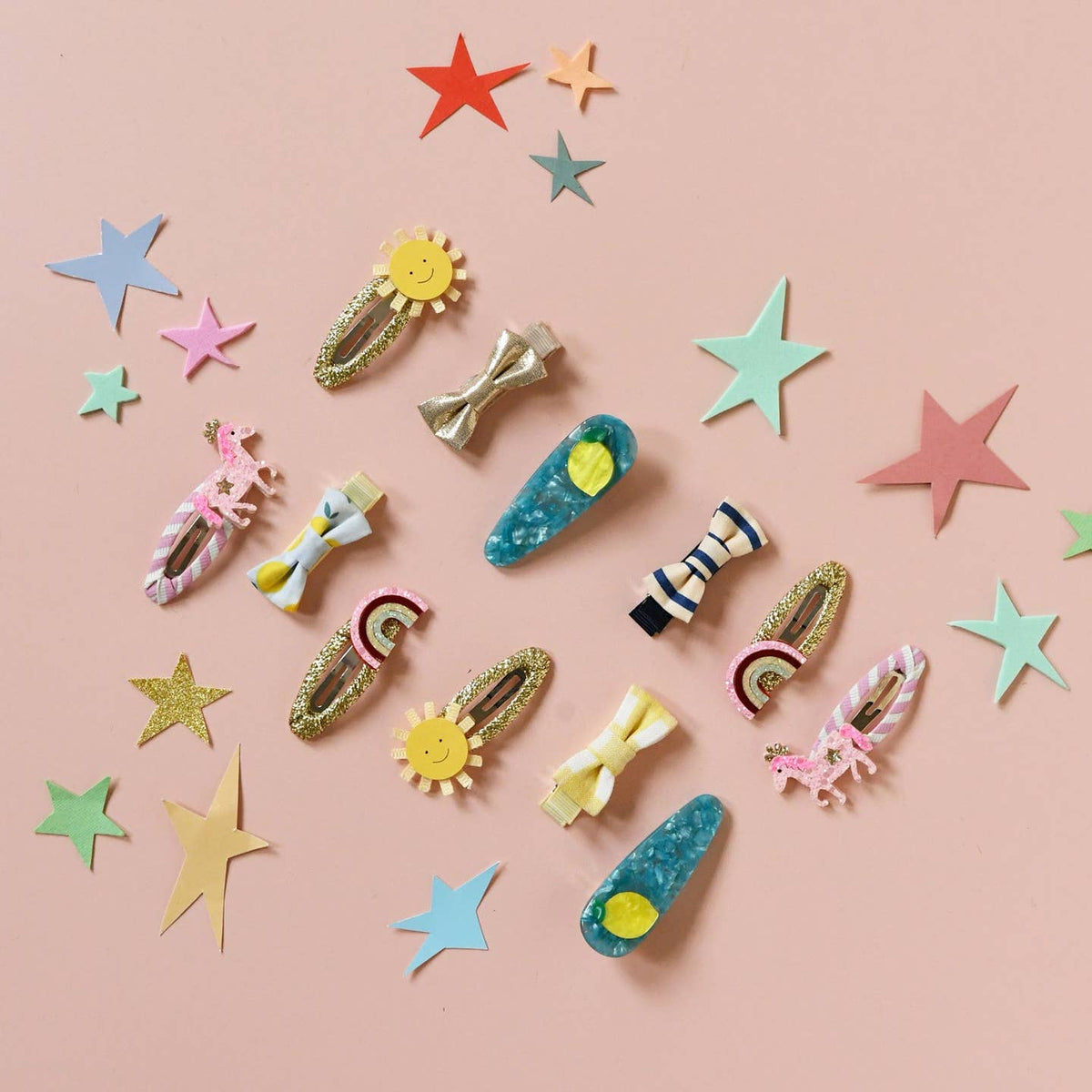 Colorful hair clips and star-shaped decorations on a pink background