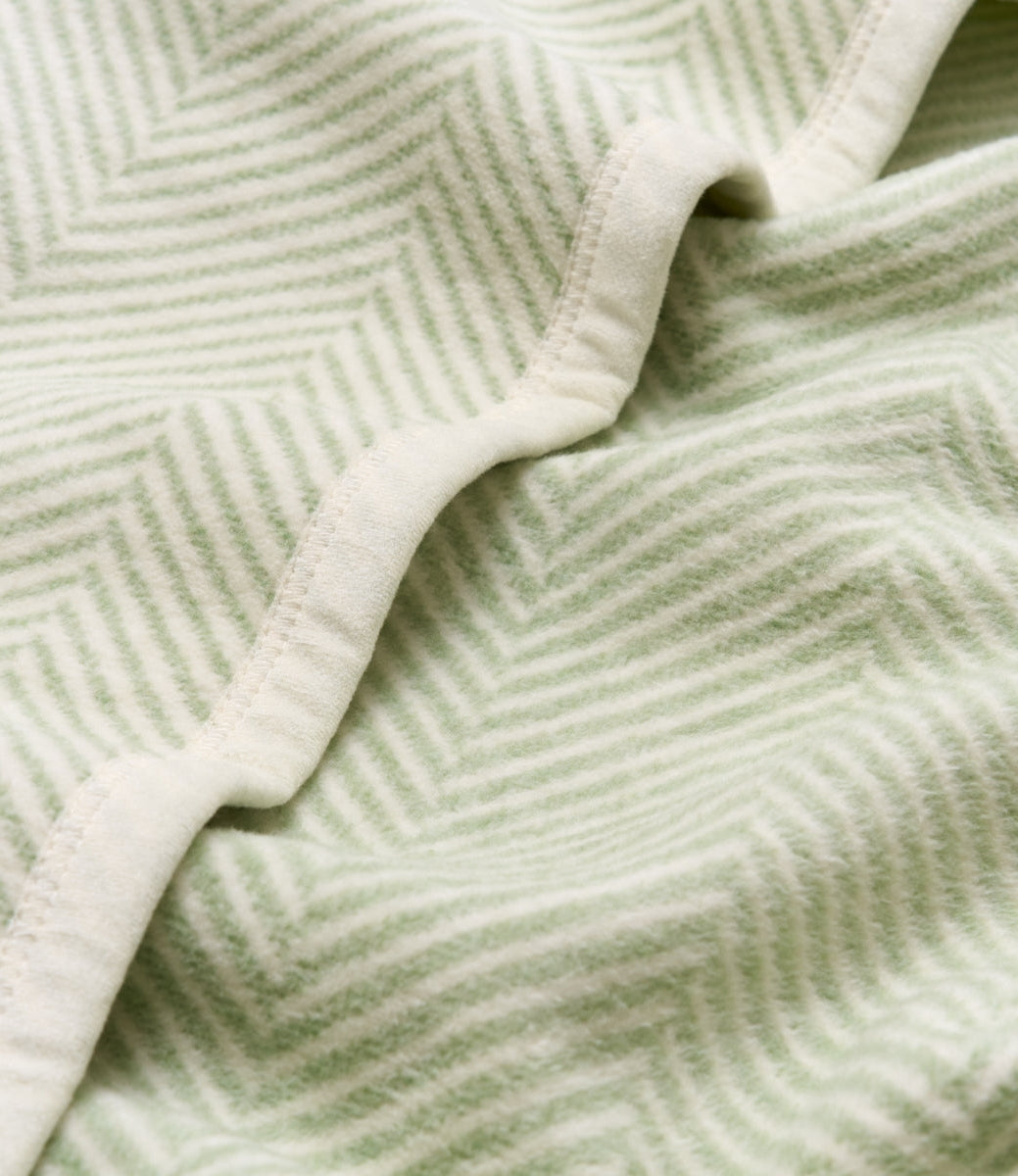 Close-up of a green and white herringbone patterned fabric.