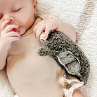 Baby wearing a brown outfit with a textured legging on a soft, beige background