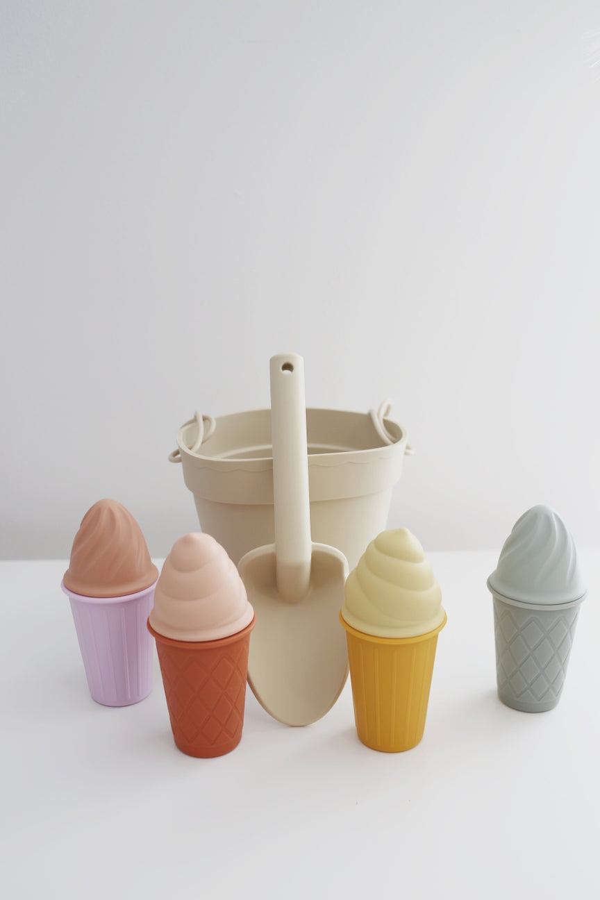 Set of colorful ice cream cones with a sand shovel on a white background