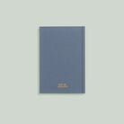 Blue notebook with a gold logo on a light gray background
