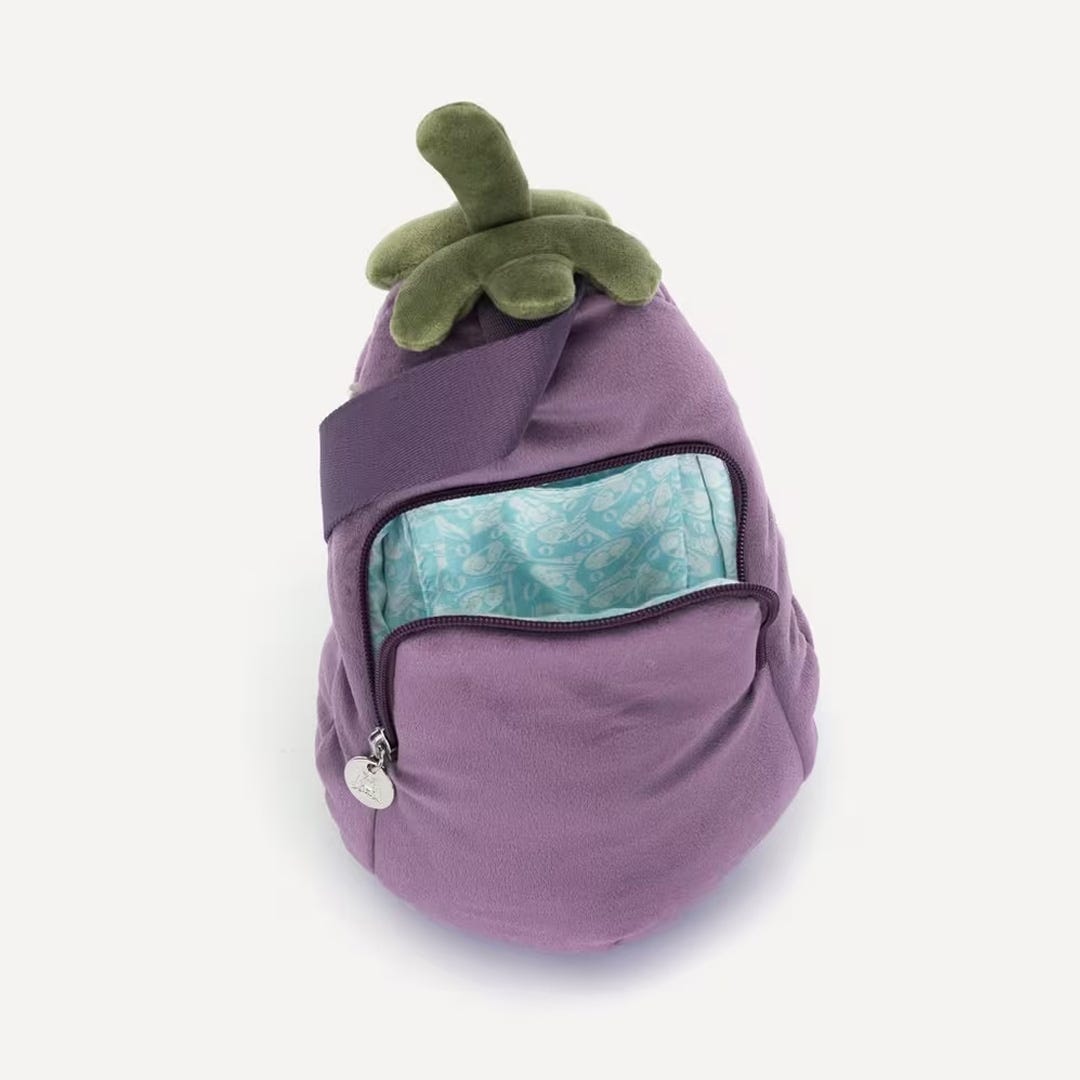 Purple backpack shaped like an eggplant with a green top on a white background