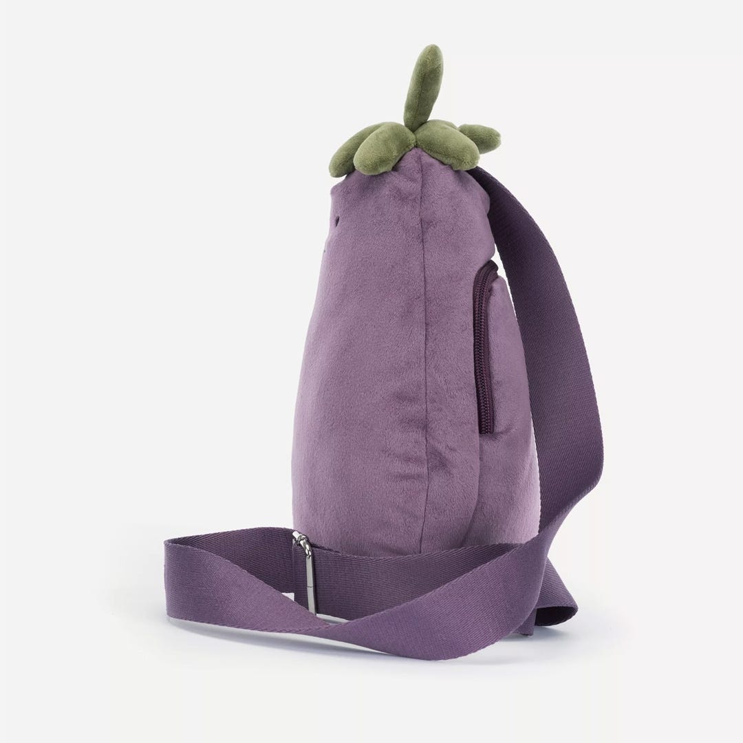 Purple backpack shaped like an eggplant with a green top on a white background