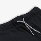 Black pants with a braided drawstring on a light gray background