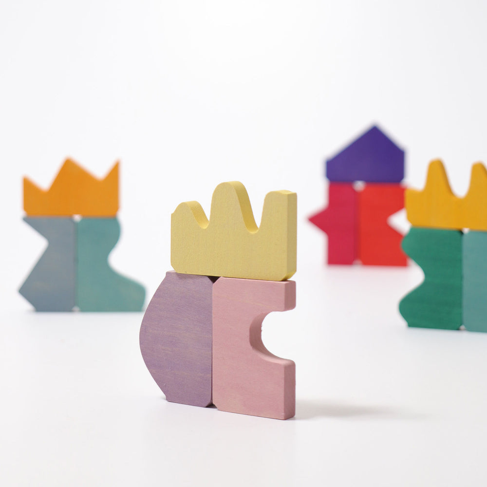 Colorful wooden toy blocks with crowns on a white background