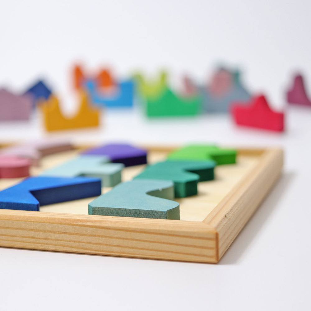 Colorful wooden puzzle on a white surface with blurred colorful shapes in the background