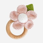 Crocheted flower teething ring with wooden base on a white background