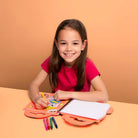 Young girl using a colorful educational toy with markers on an orange background